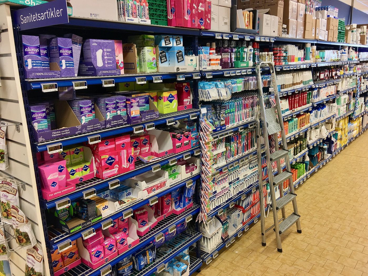 Aisle shelves with tampons, women's sanitary towels ("sanitetsartikler"), tooth brushes, health and body care products, 