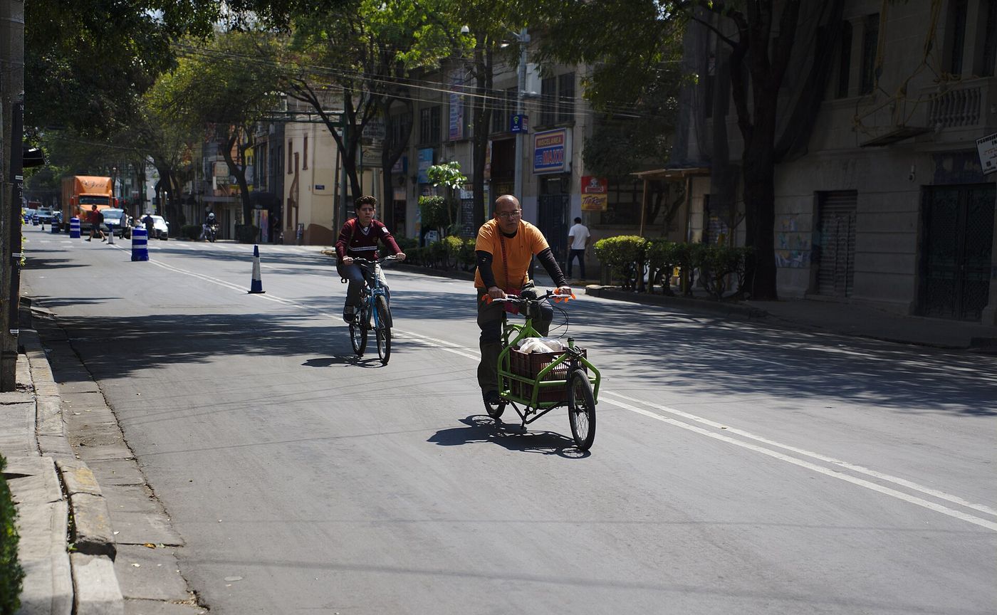 A cargo bike and a teen riding a bike in a pilot bus-bike lane in Mexico City
